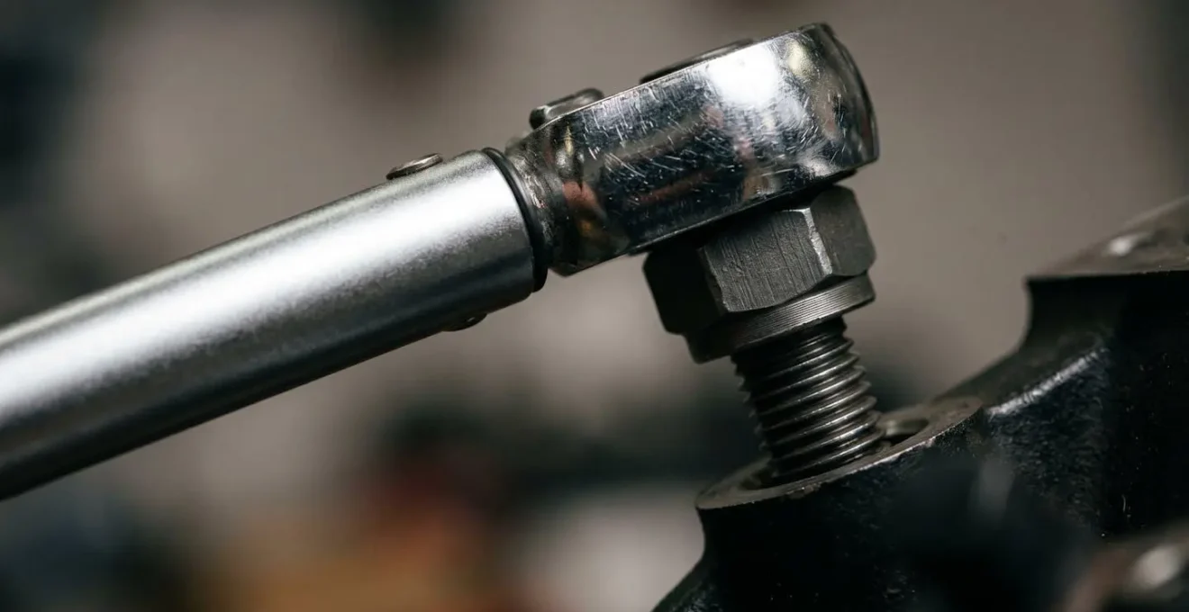 Gros plan sur une clé dynamométrique professionnelle lors du serrage d'un boulon d'ancrage de rayonnage industriel