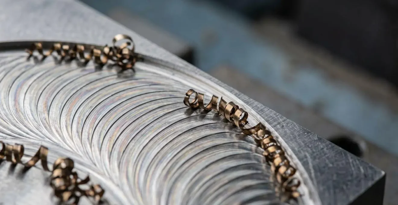 Détail macro d'une opération de fraisage trochoïdal sur pièce métallique avec copeaux